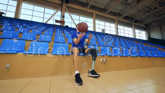 残疾人一边滚球一边坐在篮球场仿生假肢视频的预览图