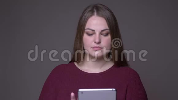 用平板电脑特写年轻超重白种人女性的特写镜头用绿色的彩色屏幕拍摄视频的预览图