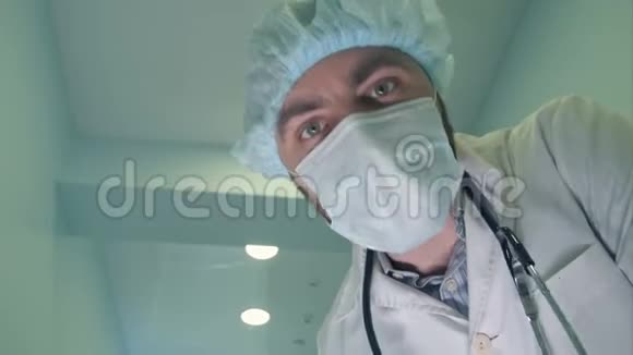 戴面具的医生低头看病人检查他的意识视频的预览图