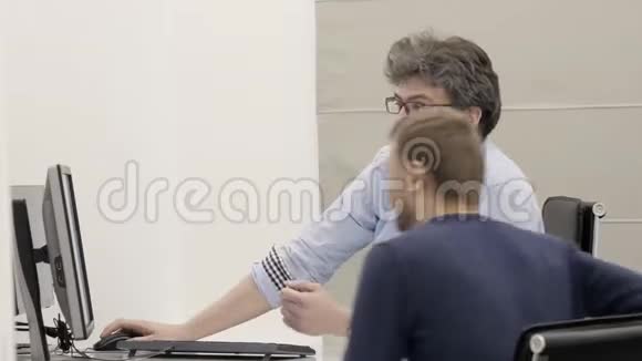 商务人员使用个人电脑在办公室开会时男士交谈视频的预览图