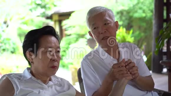 一对亚洲老年夫妇在生活问题上手牵手视频的预览图
