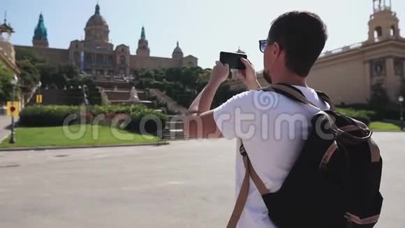 男游客正在阳光明媚的日子里为加泰罗尼亚国家美术馆拍照视频的预览图