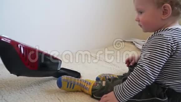 小男孩在玩吸尘器直到妈妈在吸尘视频的预览图