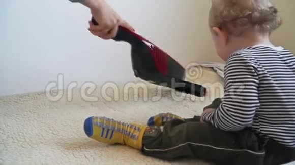 小男孩在玩吸尘器直到妈妈在吸尘视频的预览图