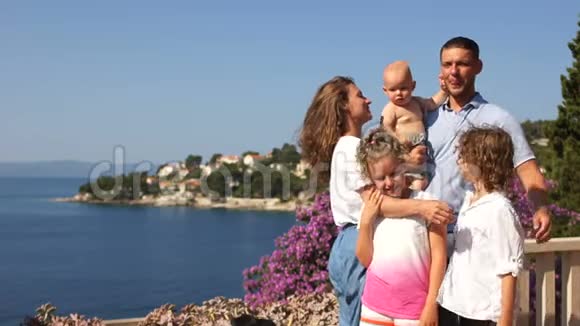 露台海边父母带孩子假期带孩子暑假有三个孩子的幸福家庭视频的预览图
