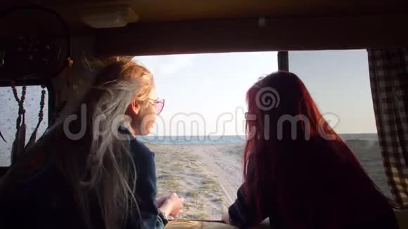 透过窗户看到一辆自动拖车在海上两个女人之间流动的头发在风中飘扬的光线视频的预览图
