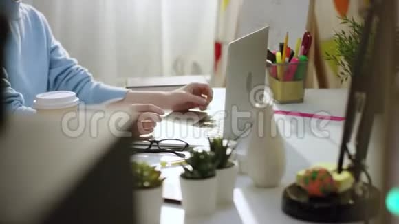 年轻漂亮的女人用笔记本电脑发短信用耳机听音乐视频的预览图