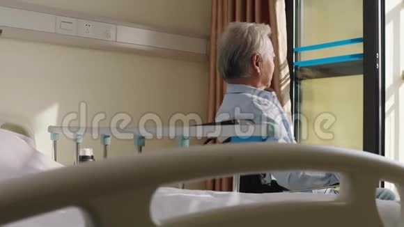 坐在靠窗的轮椅上的亚洲老人视频的预览图