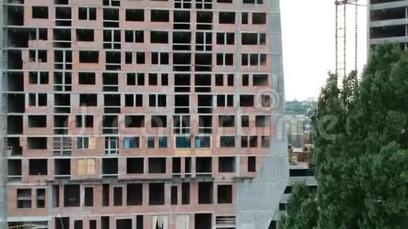 一栋砖混高层建筑施工中住宅楼的鸟瞰图在一棵树附近铁路视频的预览图