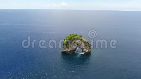 巨大的岩石有一个拱门在海洋中央蓝色的水阳光明媚4K视频的预览图