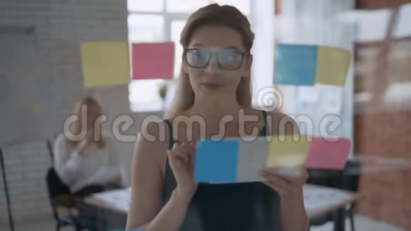 一个成功的女孩中弹严肃的商业女性使用平板电脑和在贴纸上做笔记的肖像视频的预览图