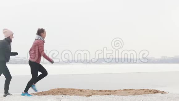 两名运动女子在雪地海滩上当场奔跑视频的预览图