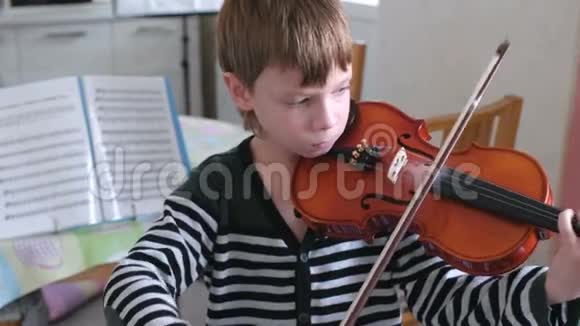 八岁的男孩正在学习拉小提琴视频的预览图