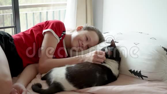 可爱的少女和她的猫玩在床上睡着了视频的预览图