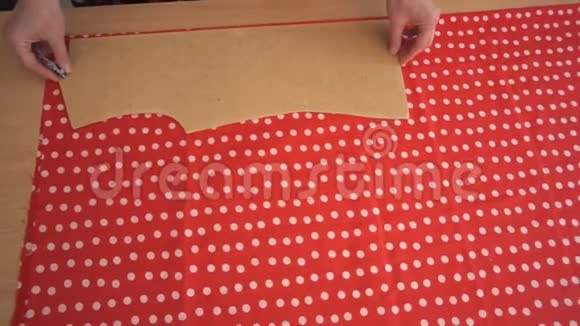 女裁缝轻轻地在红色的带有白色圆点图案的布料上做缝纫视频的预览图