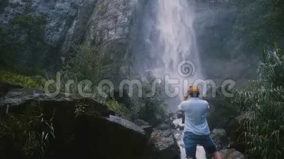 回头看年轻快乐的游客在风景优美的斯里兰卡热带丛林瀑布拍照视频的预览图