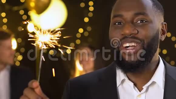 开朗的非裔美国人在庆祝新年的晚会上举着孟加拉灯视频的预览图