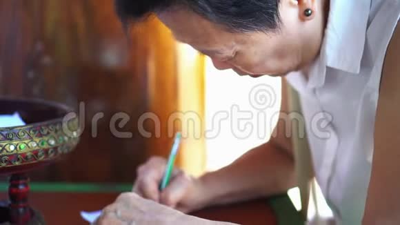 亚洲资深妇女为泰国寺庙写作捐款视频的预览图