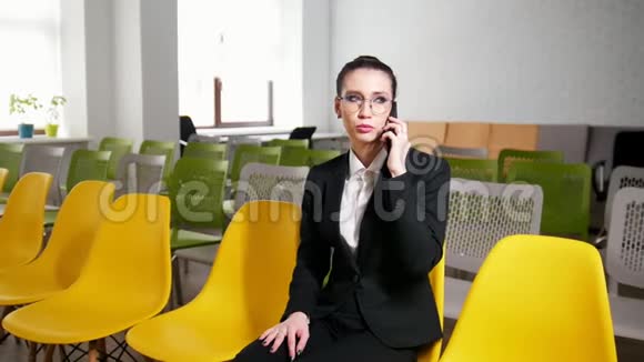 商业概念一个女人坐在商务中心用电话交谈视频的预览图