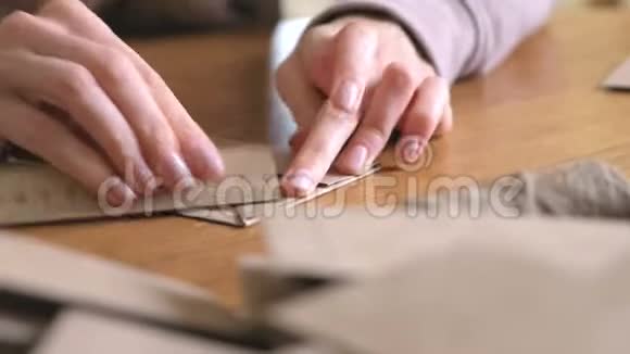女人用牛皮纸做纸袋双手特写弯曲尺子视频的预览图
