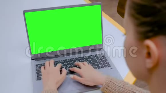女人在咖啡馆里用空白的绿色屏幕打字视频的预览图