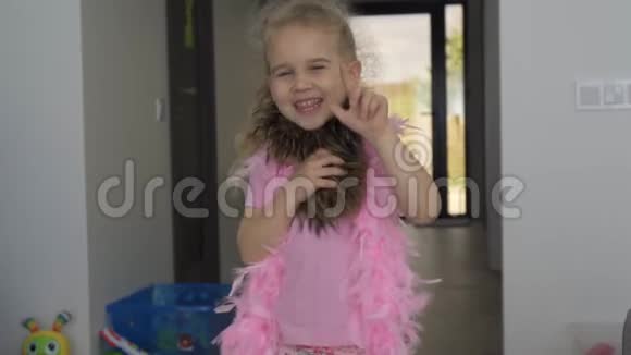 快乐的金发小女孩挥手在镜头前跳舞慢动作视频的预览图