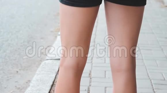 穿夏季拖鞋的女腿一个年轻女孩腿上的橡胶凉鞋一个女人站在路边走过去视频的预览图