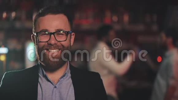 一幅微笑迷人的男人戴着眼镜在酒吧或啤酒酒吧看相机的肖像青年友谊的概念视频的预览图