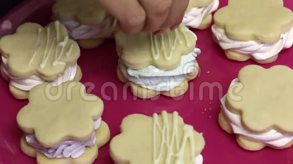 做一个棉花糖三明治一个女人洒着装饰巧克力饼干准备棉花糖和饼干放在一个视频的预览图
