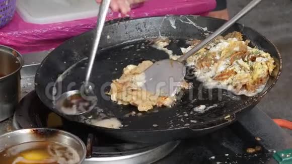 泰国人用鸡蛋和脆粉或牡蛎煎蛋卷烹调油炸贻贝出售给市场上的人视频的预览图