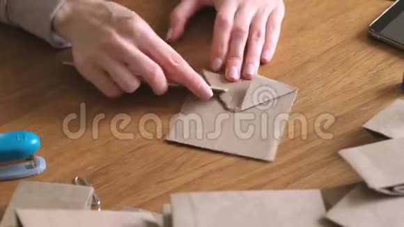 女人用牛皮纸做纸袋双手特写弯曲尺子视频的预览图