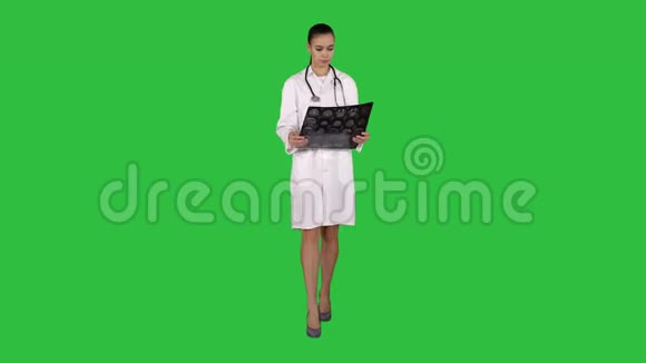 女医生带白色标签看x射线摄影图像ct扫描绿色屏幕上的MRIChroma键视频的预览图