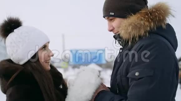 女孩温暖了那家伙双手一对恋爱中的年轻夫妇的冬天散步视频的预览图