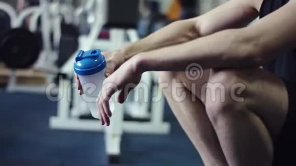 年轻的健美运动员在健身房里从摇床中摄取蛋白质视频的预览图