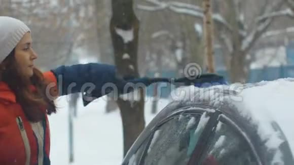 从雪地里清理汽车的女孩视频的预览图