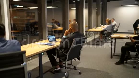 商务人士深夜在办公桌上谈论和使用笔记本电脑平板电脑和绘图视频的预览图