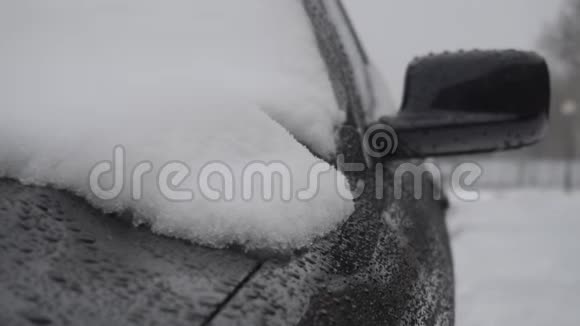 冬天雪橇在一辆现代黑色汽车的引擎盖上融化视频的预览图