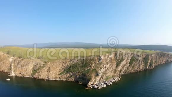 无人机正沿着陡峭的岩石海岸飞过大海视频的预览图