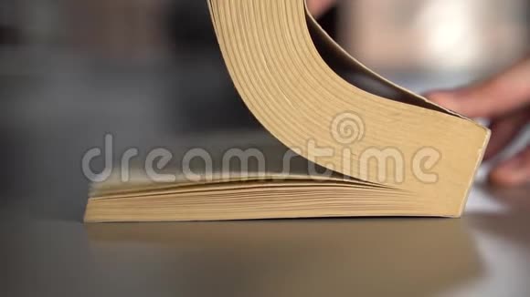 人翻阅一本旧书翻开灰色的书页视频的预览图