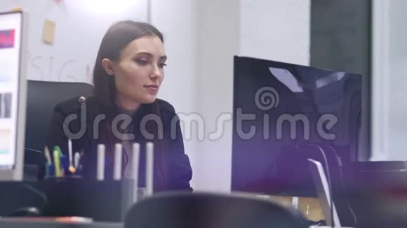 时髦的黑发商务女性对着镜头微笑现代办公室里的女商人慢动作视频的预览图