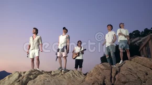 亚洲年轻人在岩石上唱歌视频的预览图
