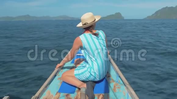 年轻女孩坐在船首的后景在旅途中寻找美丽的自然景观快乐的女人视频的预览图
