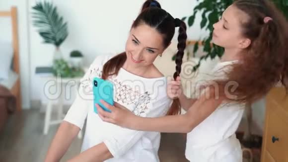美丽的母亲和女儿在电话里自拍的肖像慢动作视频的预览图