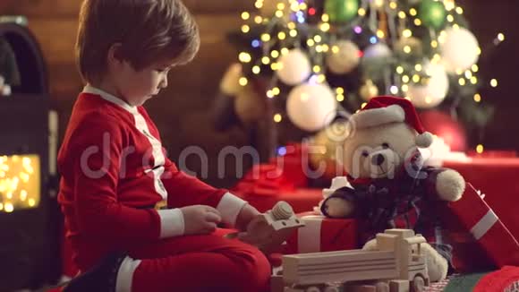 圣诞小孩戴圣诞帽带礼物过圣诞节可爱的小孩靠近圣诞树孩子幸福视频的预览图