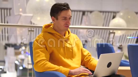 年轻人在一家现代化的大咖啡馆里手提电脑视频的预览图