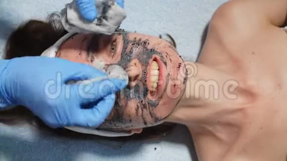 女美容师从女孩的脸上摘下面具剥去皮肤视频的预览图