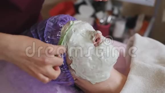 美容师戴上病人厚厚的化妆面具水疗沙龙面部年轻化视频的预览图