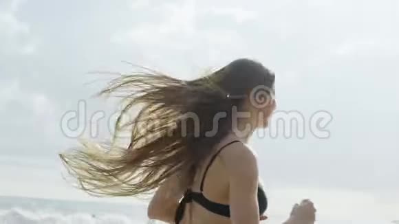 美丽的运动女孩在斯丽兰卡海滩上长发欢乐沿着海岸奔跑视频的预览图
