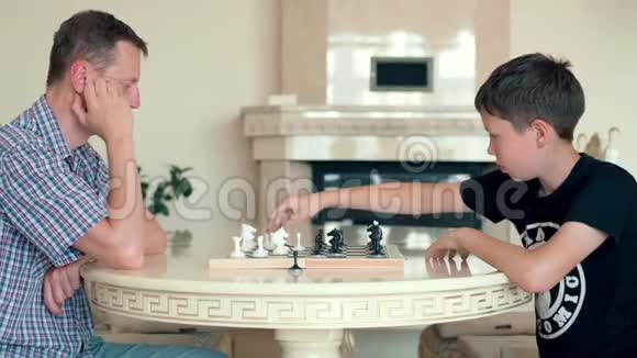 快乐的孩子在家里和一个年长的人下棋视频的预览图