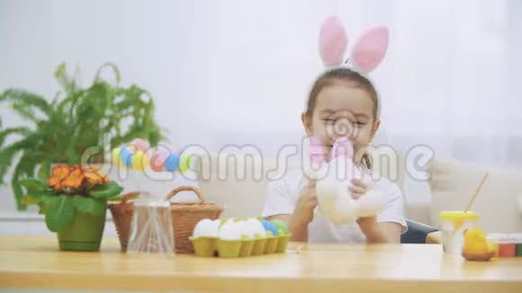 小可爱可爱的女孩在微笑和兔子的耳朵玩概念复活节假期视频的预览图